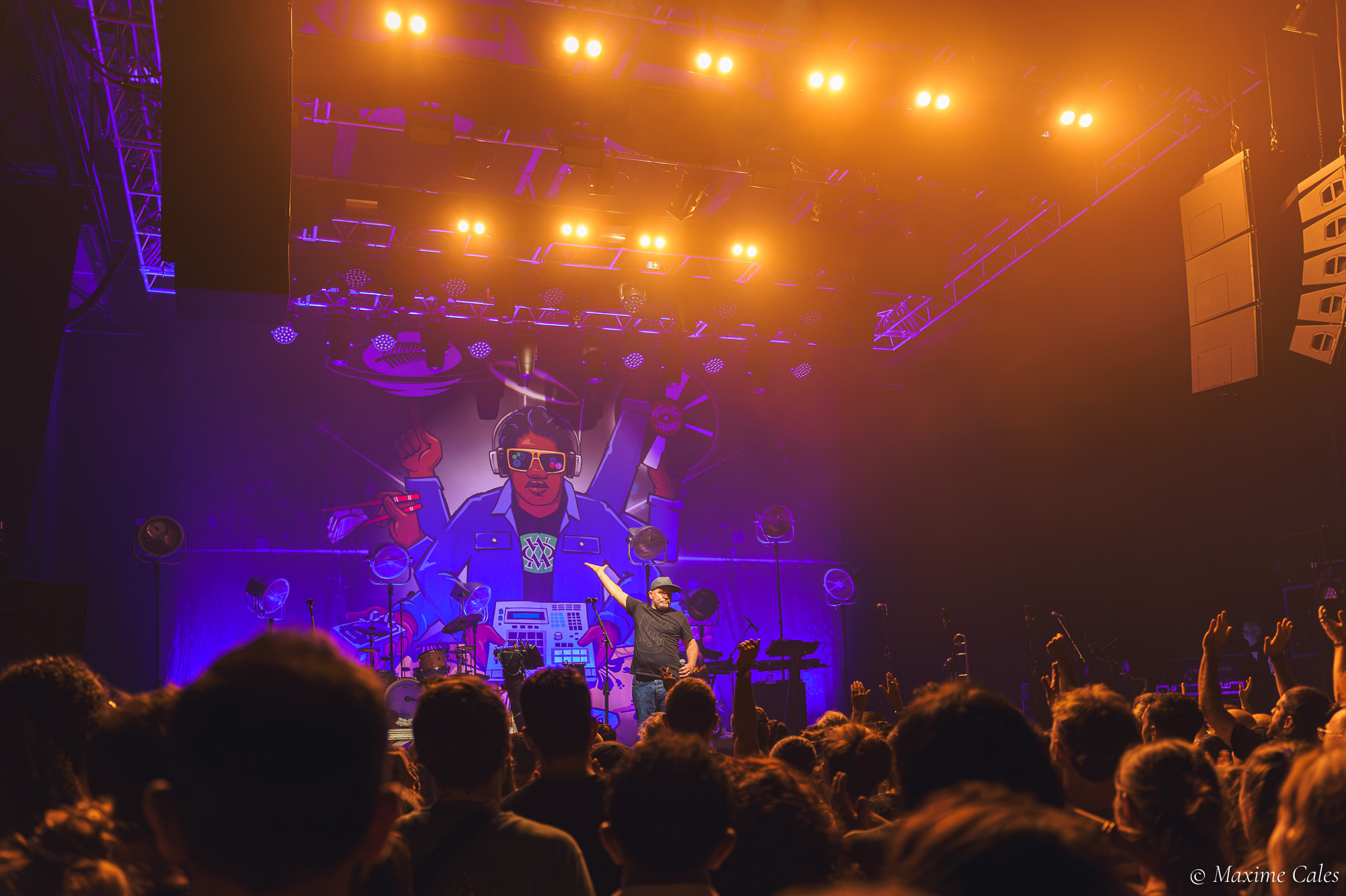 Rampe de projecteurs orangés au-dessus du public du Bikini pendant le live de Fat Freddy's Drop