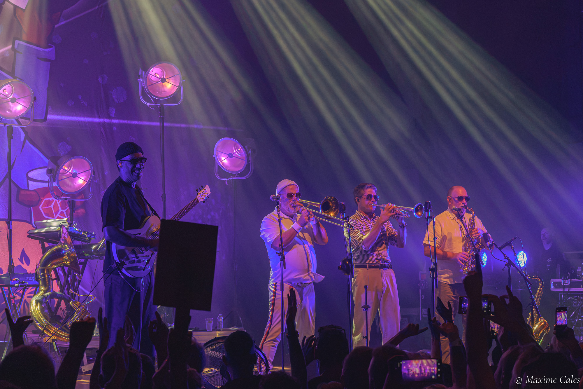 Section cuivres de Fat Freddy's Drop dans les faisceaux de lumière, trombone et trompettes